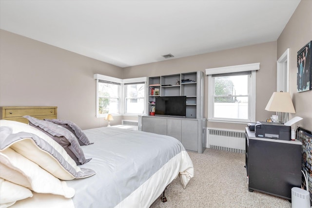 bedroom featuring radiator, light carpet, multiple windows, and visible vents