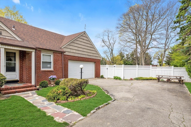 garage featuring fence and driveway