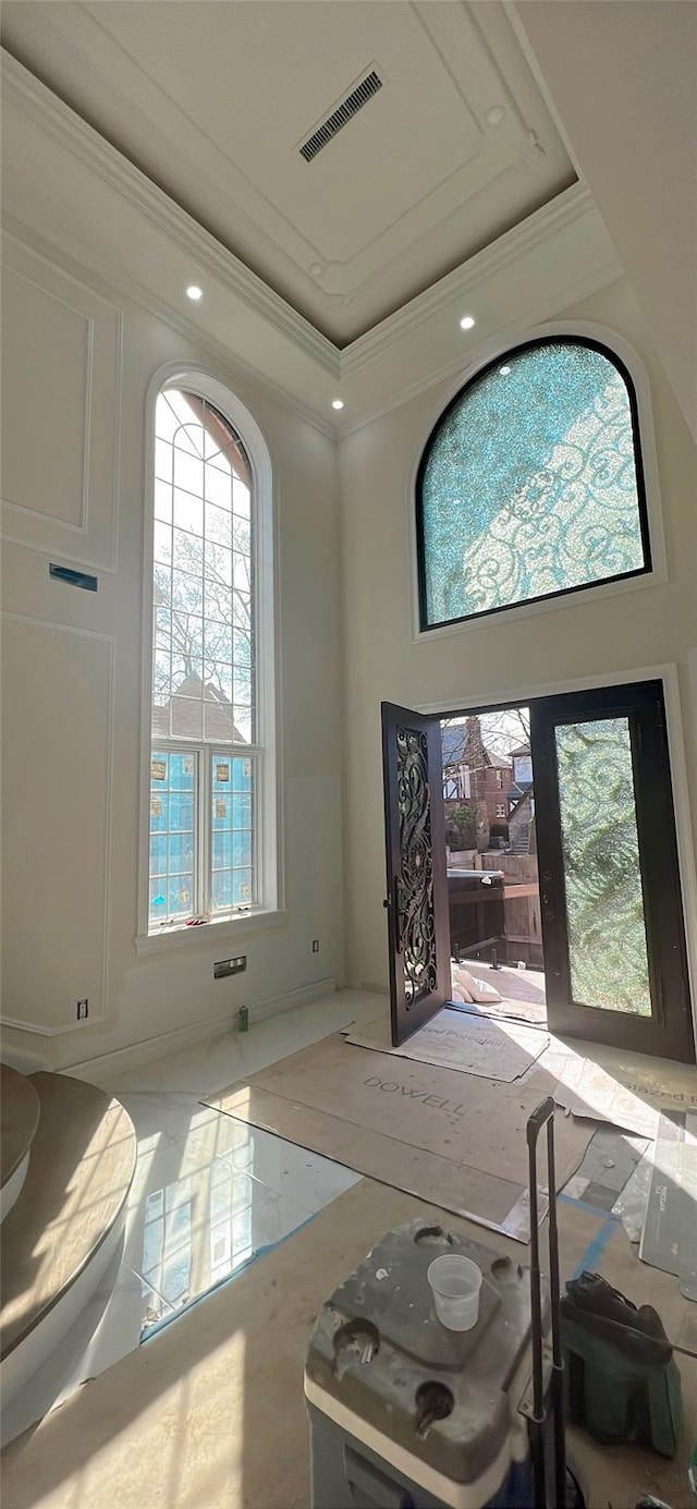 foyer entrance with visible vents, recessed lighting, a raised ceiling, and ornamental molding