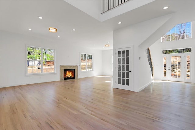 unfurnished living room featuring light wood-type flooring, recessed lighting, and a lit fireplace