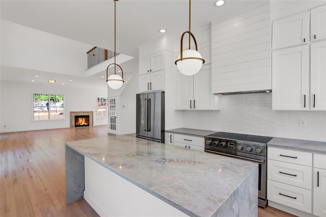 kitchen with premium range hood, light wood finished floors, white cabinets, and stainless steel appliances