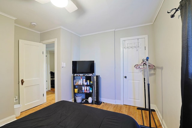 bedroom featuring ceiling fan, baseboards, crown molding, and light wood-style flooring