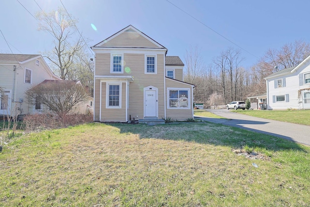 traditional-style home featuring a front lawn