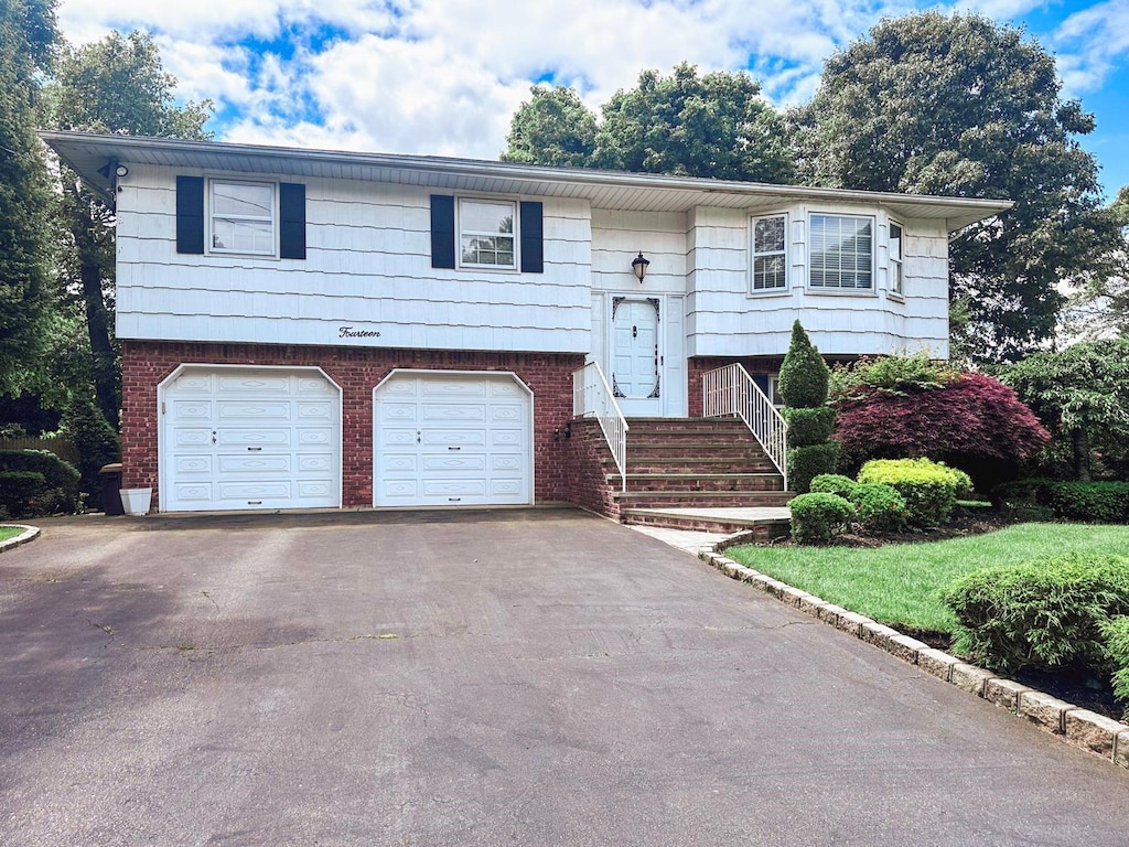 14 Scott St, Dix Hills, NY 11746 - raised ranch with an attached garage, asphalt driveway, and brick siding