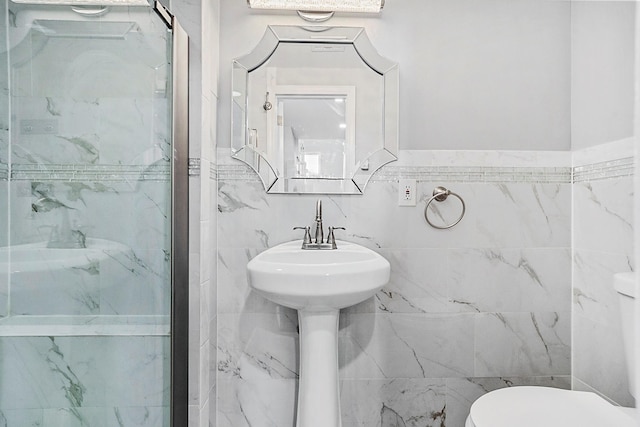 full bathroom with a shower stall, toilet, and tile walls