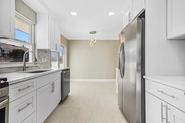 kitchen with white cabinets, a sink, baseboards, tasteful backsplash, and appliances with stainless steel finishes