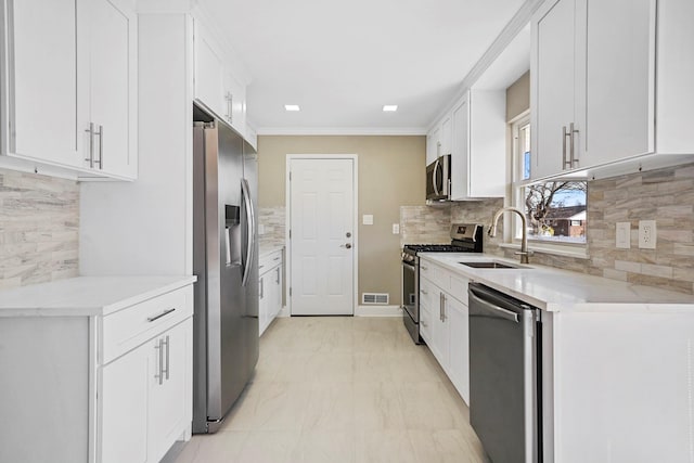 kitchen with stainless steel appliances, visible vents, a sink, and white cabinetry