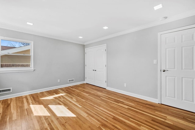 unfurnished bedroom with baseboards, visible vents, and crown molding