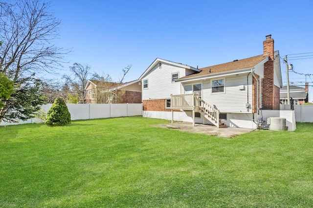 back of property featuring cooling unit, a yard, a chimney, and fence