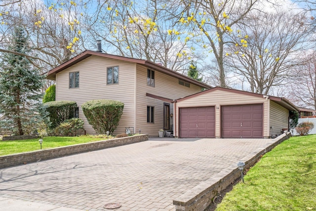 view of front of home featuring an outdoor structure, decorative driveway, an attached garage, and a front yard