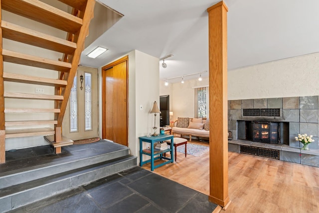 entrance foyer with track lighting, wood finished floors, and decorative columns