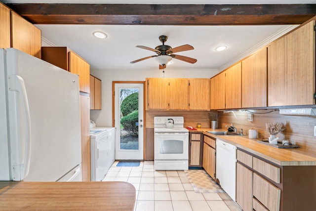kitchen with a sink, white appliances, light tile patterned floors, washer and dryer, and light countertops