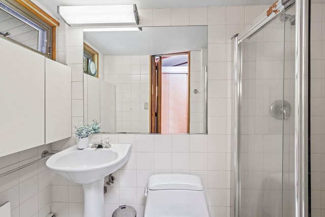 bathroom featuring tile walls, a stall shower, and toilet