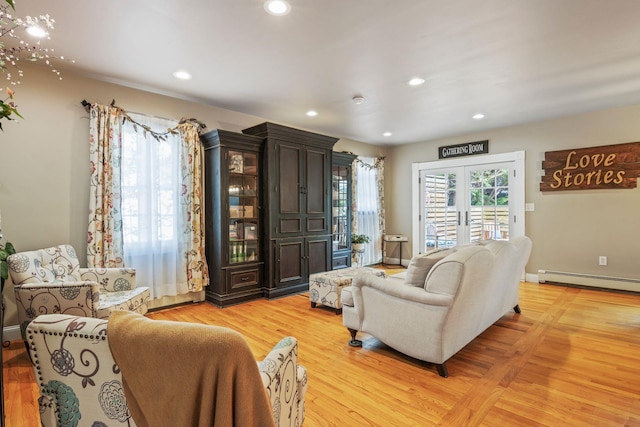 living area with a baseboard radiator, light wood-type flooring, and recessed lighting