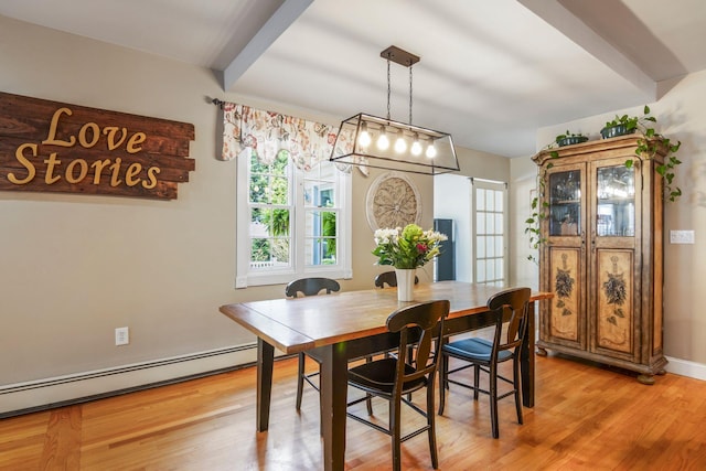 dining space featuring light wood-type flooring and a baseboard radiator