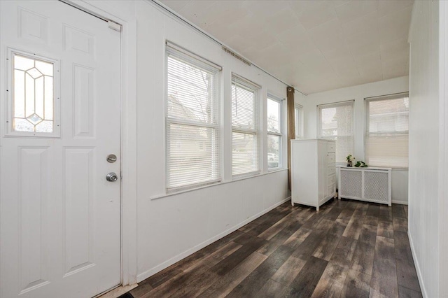 entryway with radiator heating unit, baseboards, and dark wood-type flooring