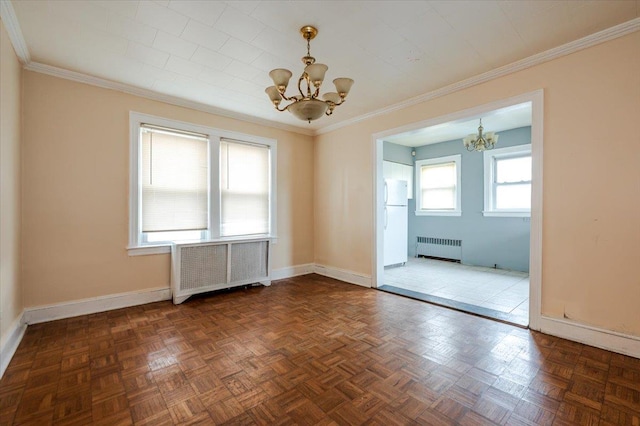 spare room with radiator heating unit, baseboards, a notable chandelier, and crown molding