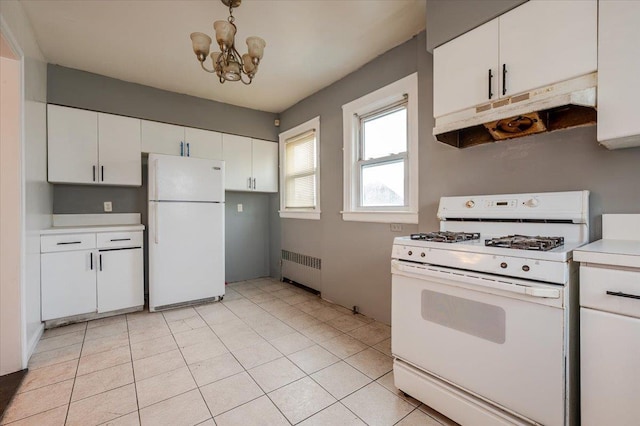 kitchen with radiator, under cabinet range hood, an inviting chandelier, light countertops, and white appliances