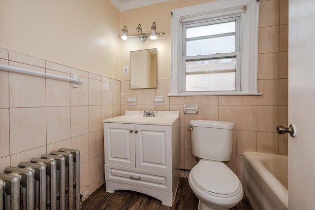 bathroom featuring toilet, tile walls, radiator heating unit, wood finished floors, and vanity