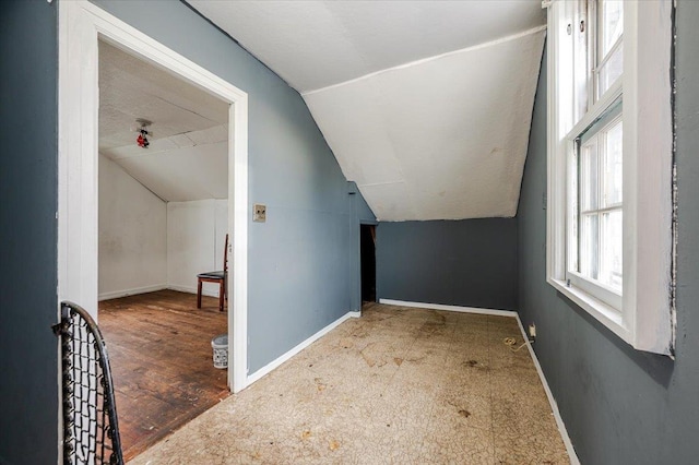 additional living space featuring vaulted ceiling and baseboards
