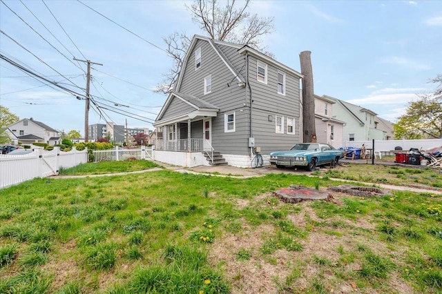 back of house featuring a yard, a fenced backyard, and a chimney