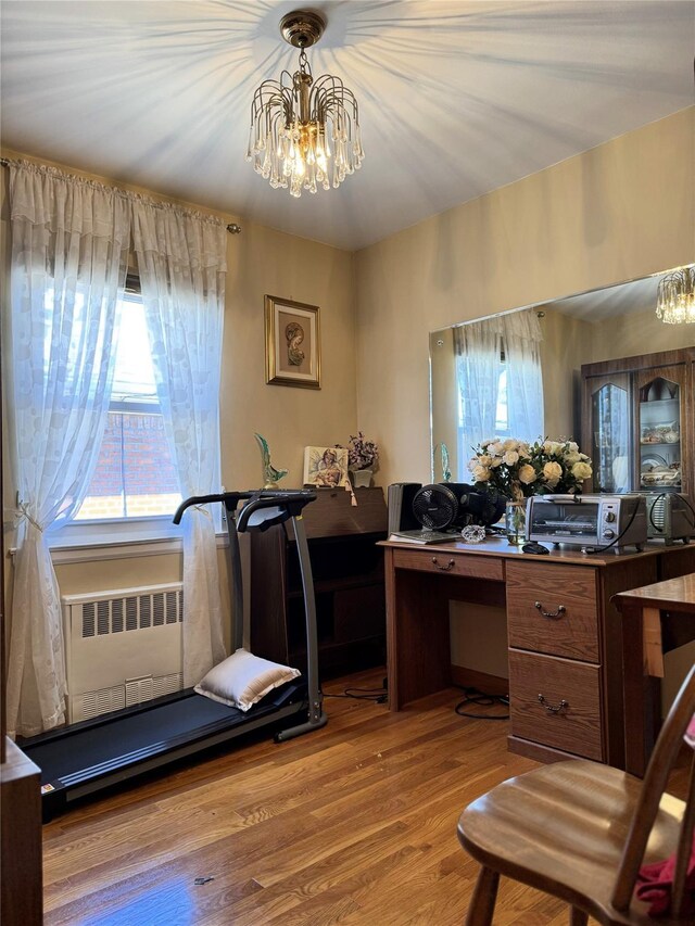 office featuring a chandelier, wood finished floors, radiator, and a toaster