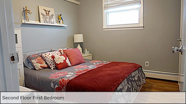 bedroom with a baseboard radiator and wood finished floors