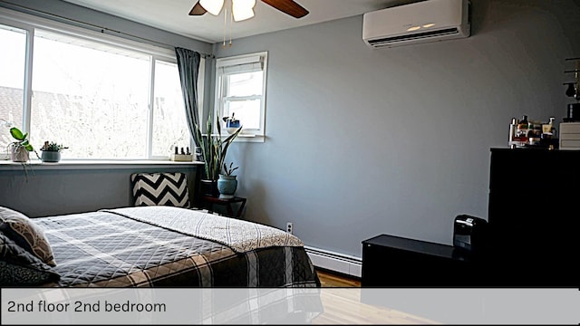 bedroom with a baseboard radiator, wood finished floors, a ceiling fan, and a wall unit AC
