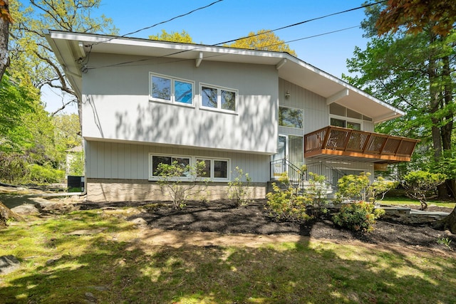 rear view of property featuring a wooden deck and stairs