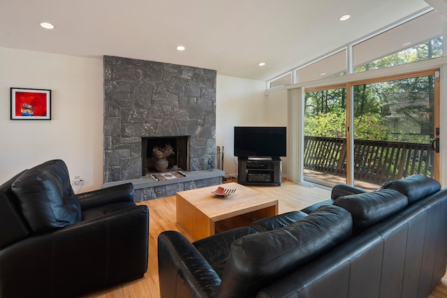 living area with recessed lighting, a fireplace, and light wood-type flooring