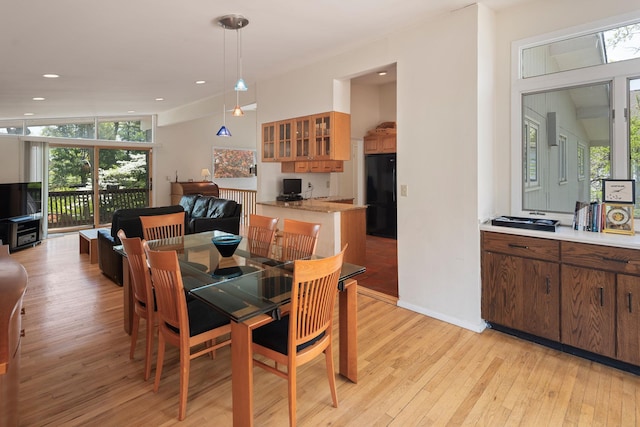 dining space with light wood finished floors, a healthy amount of sunlight, and recessed lighting