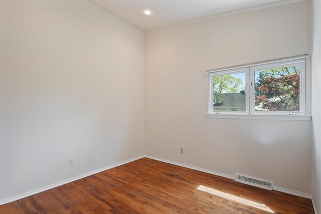 empty room featuring wood finished floors, visible vents, baseboards, and recessed lighting