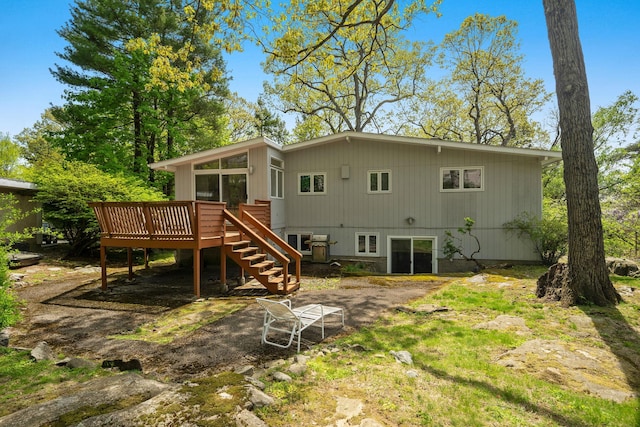 rear view of house featuring stairway and a wooden deck