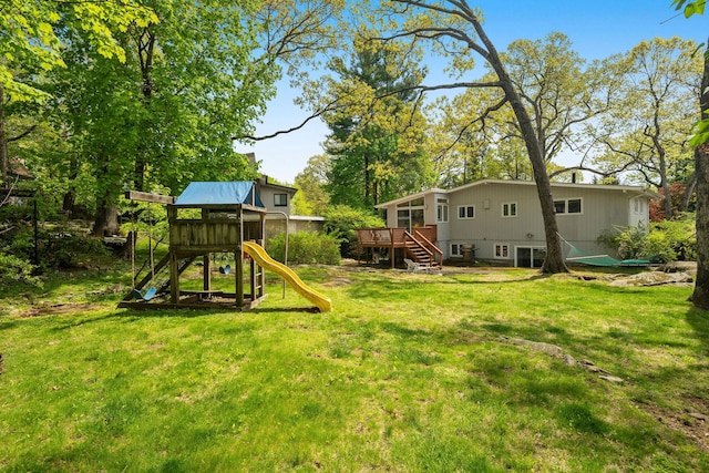 view of yard featuring stairs, a playground, and a deck
