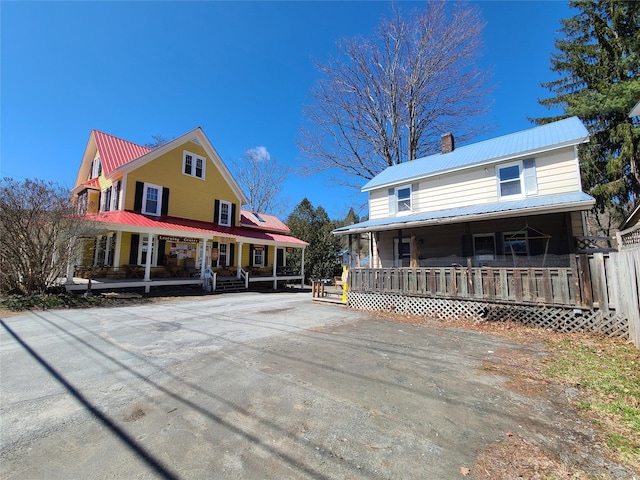108 Main St, Livingston Manor, NY 12758 - country-style home featuring a porch, metal roof, and a chimney