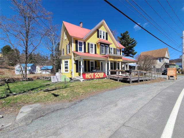 108 Main St, Livingston Manor, NY 12758 - view of front of home with metal roof, a chimney, a front yard, a porch, and a wooden deck