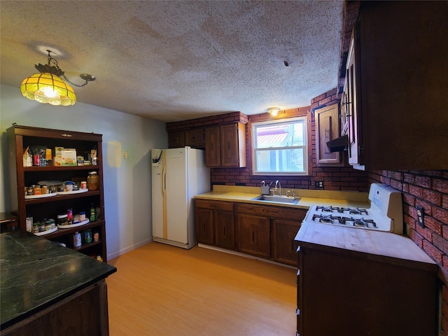 108 Main St, Livingston Manor, NY 12758 - kitchen with white appliances, a sink, a textured ceiling, light wood-type flooring, and under cabinet range hood