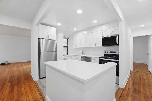 kitchen featuring white cabinets, light countertops, appliances with stainless steel finishes, and baseboards