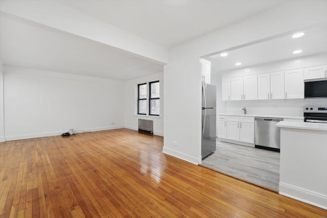 kitchen with white cabinetry, stainless steel appliances, and light countertops