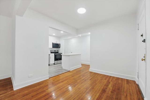 unfurnished living room with light wood-style flooring, baseboards, and recessed lighting