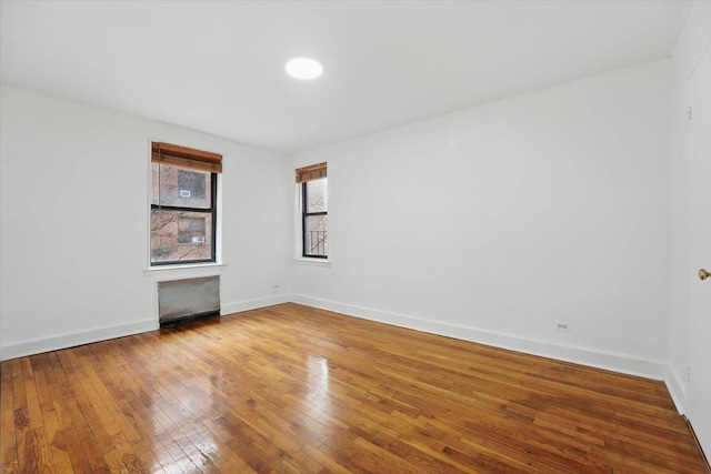 unfurnished room with wood-type flooring and baseboards