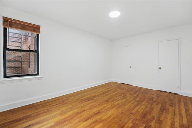 unfurnished room featuring wood finished floors and baseboards
