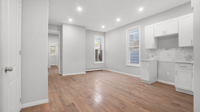 679 E 221st St, Bronx, NY 10467 - kitchen featuring a baseboard heating unit, recessed lighting, tasteful backsplash, light wood-type flooring, and white cabinetry