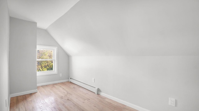 679 E 221st St, Bronx, NY 10467 - bonus room featuring a baseboard radiator, wood finished floors, lofted ceiling, and baseboards