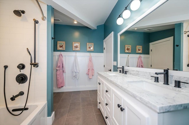 full bath with double vanity, a sink, shower / tub combination, and tile patterned flooring