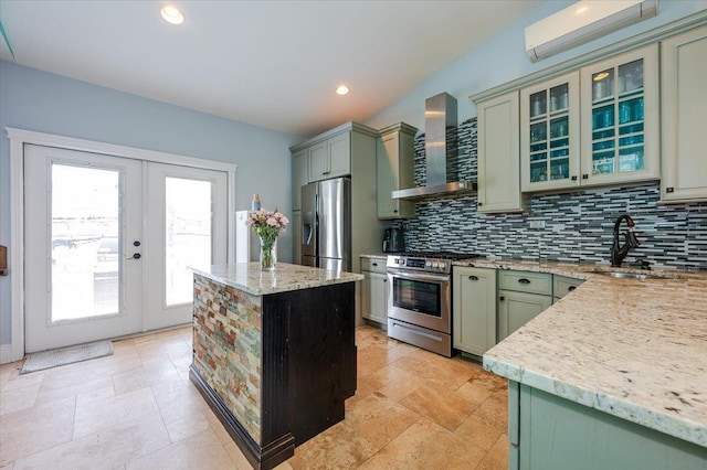 100 California St, Long Beach, NY 11561 - kitchen with wall chimney range hood, stainless steel appliances, green cabinets, and backsplash