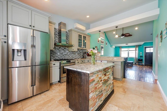100 California St, Long Beach, NY 11561 - kitchen with a peninsula, a ceiling fan, wall chimney exhaust hood, stainless steel appliances, and backsplash