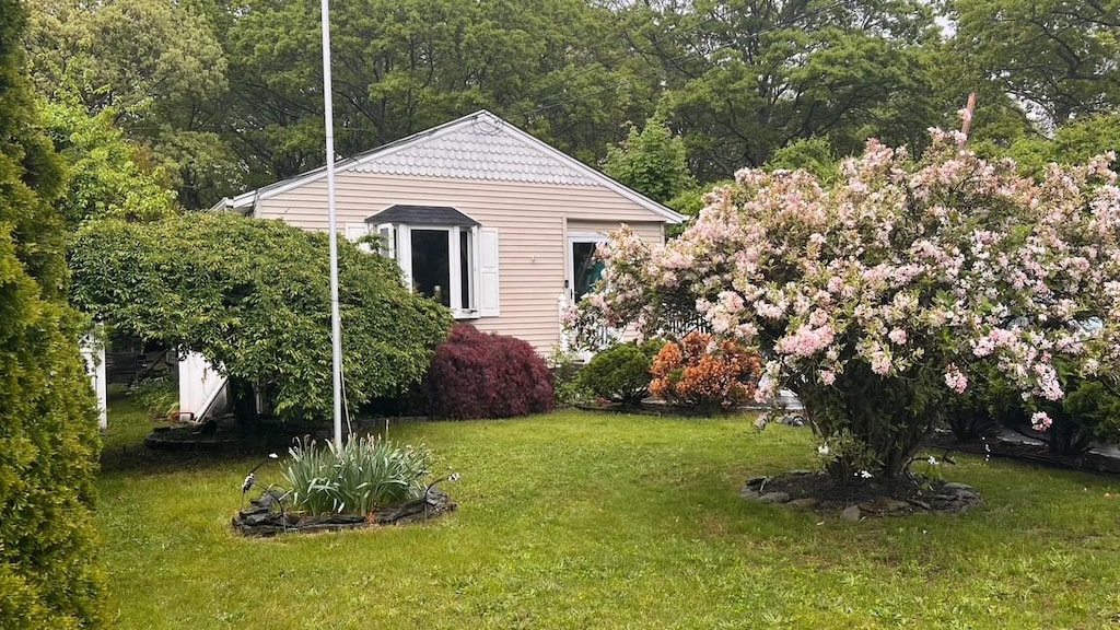 view of grassy yard with a view of trees