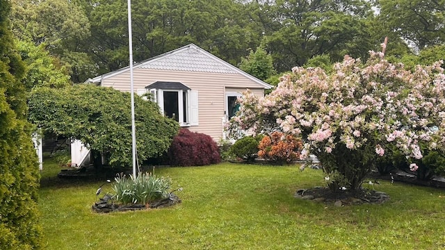 view of grassy yard with a view of trees