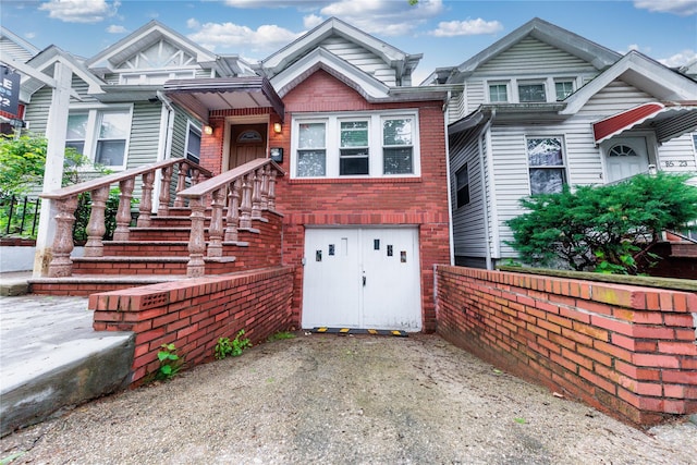 8521 80th St, Woodhaven, NY 11421 - view of front of property with a garage, brick siding, driveway, and fence